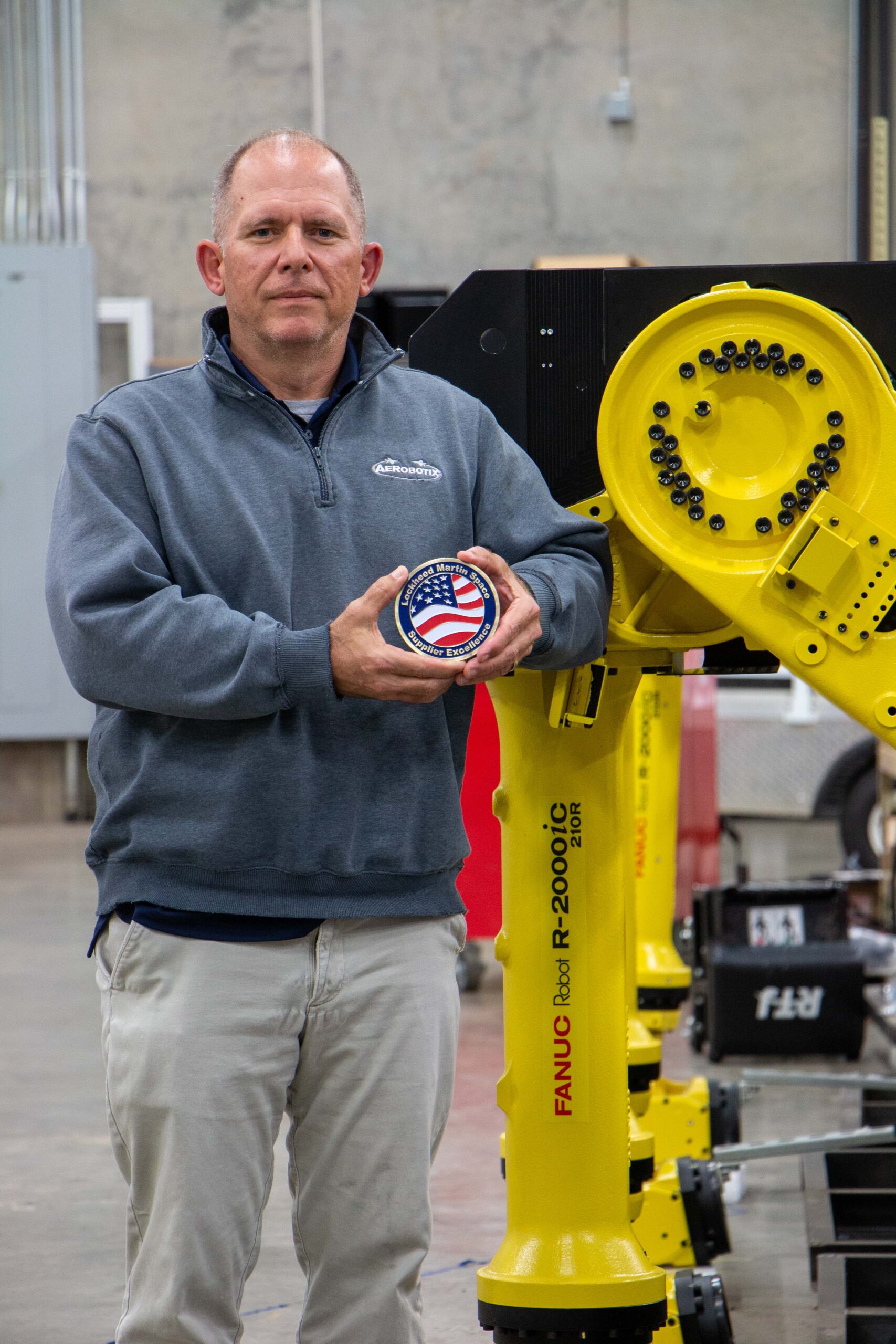 Aerobotix Senior Project Engineer Keenan Simmons holding the 2022 Lockheed Martin Supplier Recognition Award for Ease of Doing Business